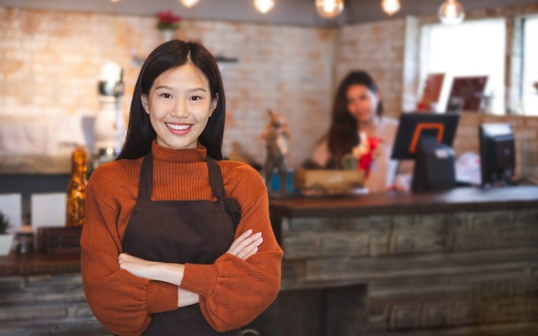 Asian owner stands infront of coffee bar