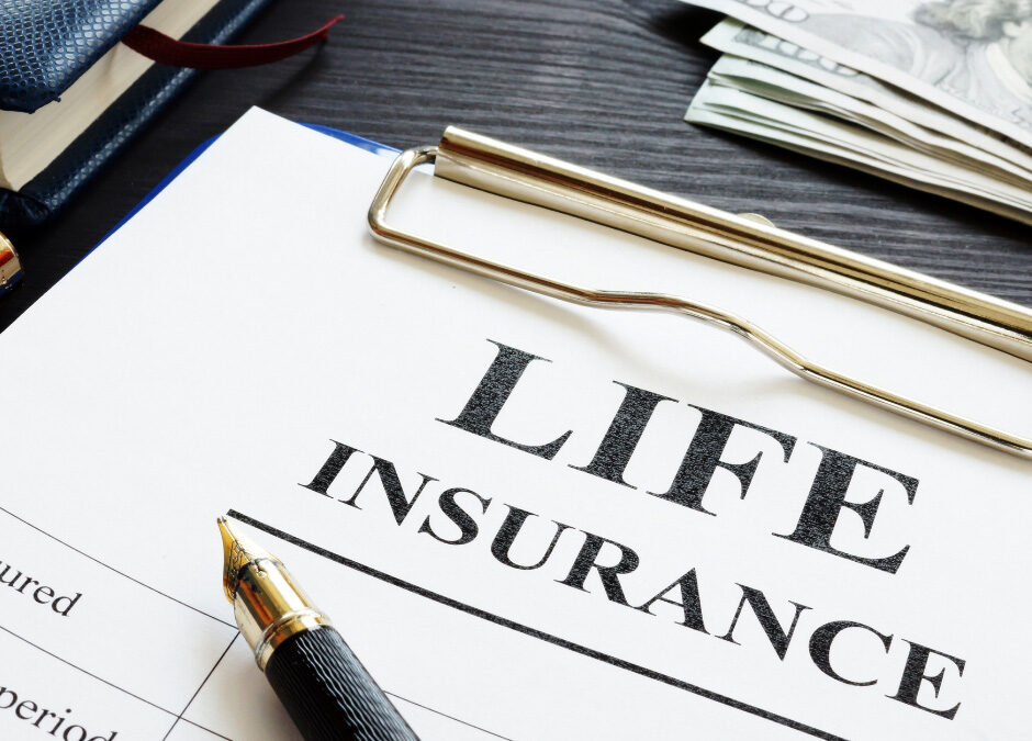 Life insurance policy document with pen, clipboard, and cash on a desk.